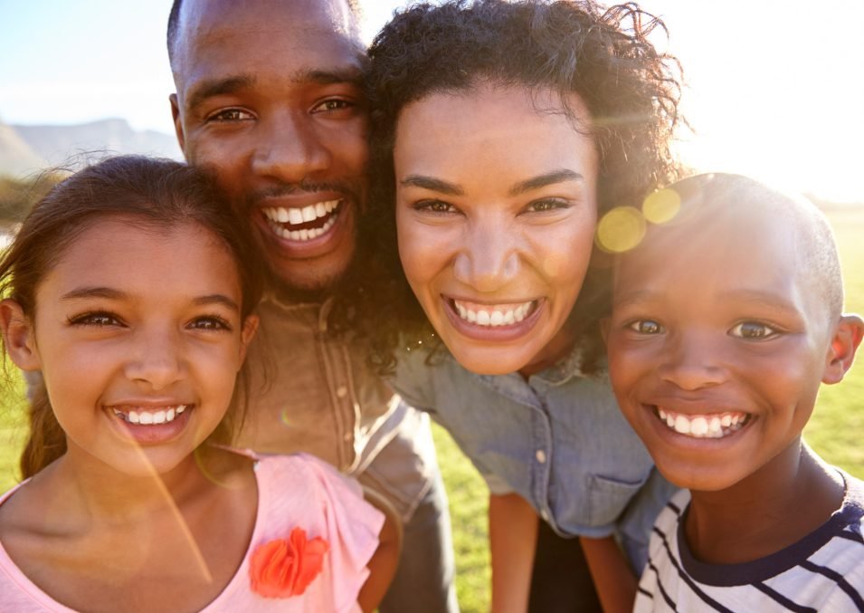 laughing-black-family-outdoors-close-up-back-lit-PPCMZD4.jpg